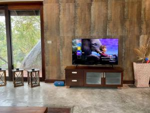uma sala de estar com uma televisão de ecrã plano num suporte em Hill Top Retreat — by Sea Dance Resort em Koh Samui