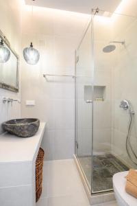 a bathroom with a glass shower and a sink at Delfini Resort in Agios Georgios Pagon