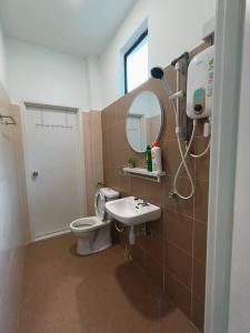 ein Badezimmer mit einem WC, einem Waschbecken und einem Spiegel in der Unterkunft SecreteGarden627 3 storey 5r4b PartyHome 12-20pax in Malakka