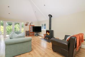 un soggiorno con divano e camino di Garden Cottage a Farnham