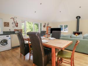 comedor con mesa, sillas y sofá en Garden Cottage en Farnham
