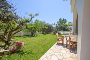 d'une terrasse avec une table et des chaises dans la cour. dans l'établissement Delfini Resort, à Agios Georgios Pagon