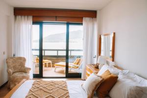 Un dormitorio con una cama y vista al mar. en Just Like Home - Apê do Rio, en Caminha