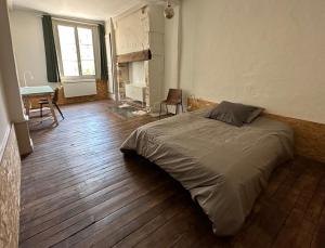 een slaapkamer met een bed, een tafel en een bureau bij Chambre dans maison originale en centre ville in Troyes