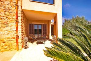 a patio of a house with chairs and a building at New, Premium Finca mit Starlight-Pool! South-East Coast, Cala d Or in S'Horta