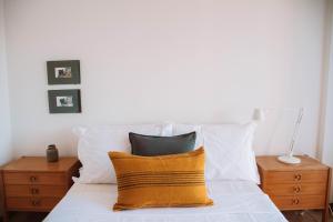 Un dormitorio con una cama con almohadas amarillas y blancas. en Just Like Home - Apê do Rio, en Caminha