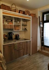uma cozinha com armários de madeira e uma prateleira com cestos em Green Empathy Studio Castel Gandolfo em Castel Gandolfo