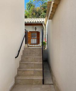un escalier menant à une maison avec une porte dans l'établissement Chalés do Alferes, à Tiradentes
