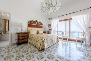a bedroom with a bed and a chandelier at Villa Gina, Anacapri in Anacapri +43 photos
