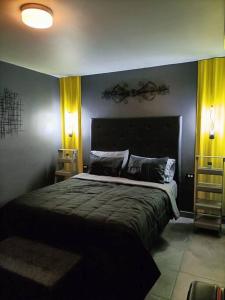 a bedroom with a large bed with yellow curtains at Depto San Angel 4, Planta alta, Cd Juarez Chih Mex in Ciudad Juárez