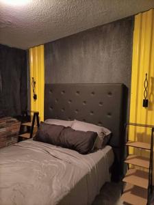 a bedroom with a bed with a large headboard at Depto San Angel 4, Planta alta, Cd Juarez Chih Mex in Ciudad Juárez