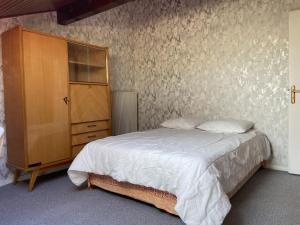 sypialnia z łóżkiem i drewnianą szafką w obiekcie Saint-Jorioz Maison , vue montagnes, jardin clos , 8pers w mieście Saint-Jorioz