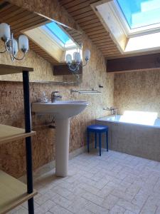 W łazience znajduje się umywalka i wanna z oknem dachowym. w obiekcie Saint-Jorioz Maison , vue montagnes, jardin clos , 8pers w mieście Saint-Jorioz