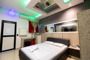 a bedroom with a large bed in a room at Troia Motel in Foz do Iguaçu