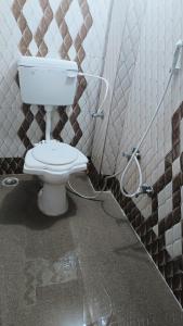 a bathroom with a white toilet in a stall at Hotel 100 Meter in Jabalpur