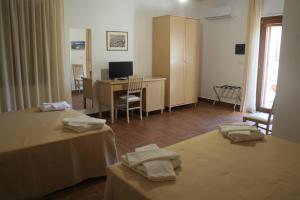 Zimmer mit 2 Betten und einem Schreibtisch mit einem Computer in der Unterkunft Il Podere dell'Angelo Old Country House in Belvedere Marittimo
