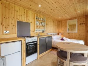 a kitchen with a table and a bed in a room at River Lodge in Aldeburgh