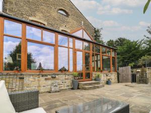 einen Wintergarten mit großen Glasfenstern auf einem Backsteingebäude in der Unterkunft Lee House Farm in Halifax