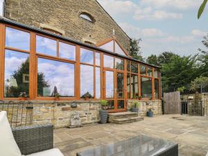 a conservatory with large glass windows on a brick building at Lee House Farm in Halifax