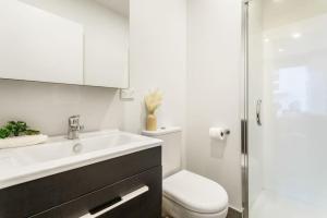 a bathroom with a sink and a toilet and a shower at Cosy Studio in Central Avondale - Netflix Wi-Fi in Auckland