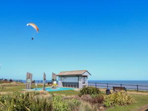 a kite flying over a swimming pool next to the ocean at 31 Siesta Mar Chalet Park in Norwich