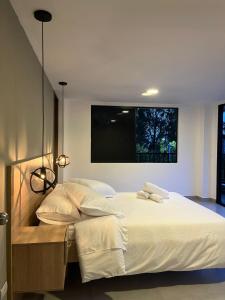 a bedroom with a large bed with white sheets and pillows at Casa campestre en el corazón de envigado in Envigado