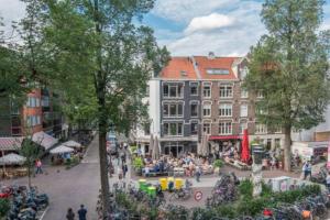 a crowd of people in a town square with buildings at Groot mooi 2 etage loft met dakterras in De Pijp. in Amsterdam