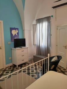 sypialnia z łóżkiem, krzesłem i komodą w obiekcie Suite San Giovanni w mieście Torre Santa Susanna