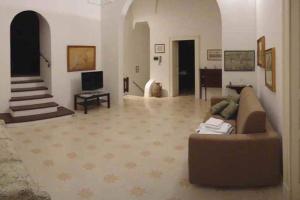 ein Wohnzimmer mit einem Sofa und einem TV in der Unterkunft Antica Residenza Piazza Pisanelli in Tricase