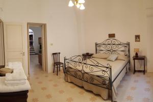ein Schlafzimmer mit einem Bett, einem Tisch und einem Stuhl in der Unterkunft Antica Residenza Piazza Pisanelli in Tricase
