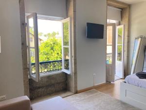 a bedroom with a window and a bed and a tv at Coreto Bento Freitas in Vila do Conde