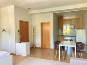 a living room with a table and a kitchen at Coreto Bento Freitas in Vila do Conde +11 photos