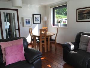 uma sala de estar com um sofá e uma mesa em Heron’s View em Arrochar