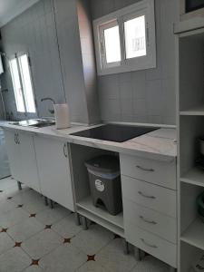 a white kitchen with a sink and a counter at Apartamento Juan in Vejer de la Frontera