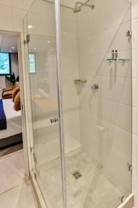 een douche met een glazen deur in de badkamer bij Zimbali Lakes Boulevard Suites 218 in Ballito