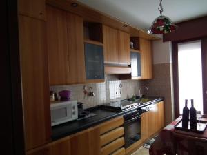 a kitchen with wooden cabinets and a microwave at La casa di Giò in Tirano +9 photos
