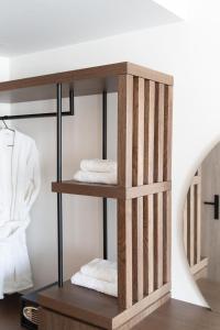 a wooden towel rack with three folded towels at Athens Design Suites in Athens