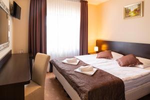 a hotel room with a bed with two napkins on it at Pensjonat Solar in Mielno