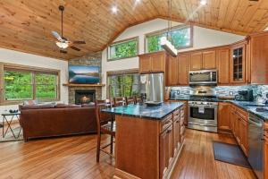a kitchen with wooden cabinets and a living room with a couch at Welcome to Padre's Mountain Paradise! in Blowing Rock