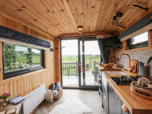 a kitchen with wooden walls and a wooden ceiling at Greenacres Carriage in Maybole