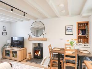a living room with a table and a fireplace at Bwthyn Lili Lily Cottage in Cemaes Bay