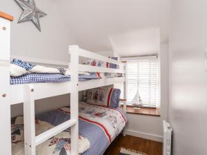 a bedroom with two bunk beds in a room at Bwthyn Lili Lily Cottage in Cemaes Bay