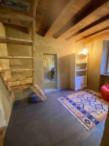 um quarto no sótão com uma escada e um tapete em La Casetta nel bosco! em Stazzema