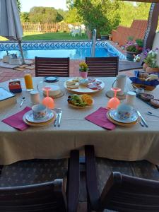 a table with plates of food on it next to a pool at Manta Rota Beach, Bed & Breakfast in a villa,privat pool in Manta Rota