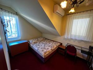 1 dormitorio con cama, escritorio y ventana en Zajazd Skorpion B&B, en Oświęcim