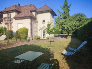 Una mesa y sillas frente a una casa en Appartement des rives de l'Ehn, en Krautergersheim