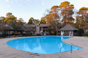 a large blue swimming pool in front of a house at Mileys Place at Pinehurst in Pinehurst