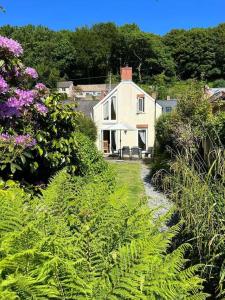 a large white house in the middle of a garden at Spring Cottage, Little Haven, a minute from beach in Little Haven
