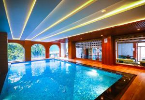 a large swimming pool in a house with a large window at Hotel JP Hills Rishikesh in Rishīkesh