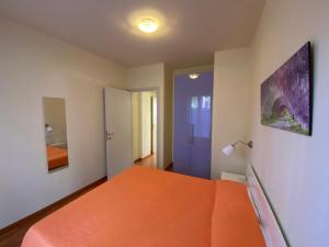 um quarto com uma cama laranja e uma porta azul em Casetta, 54 em Sirolo